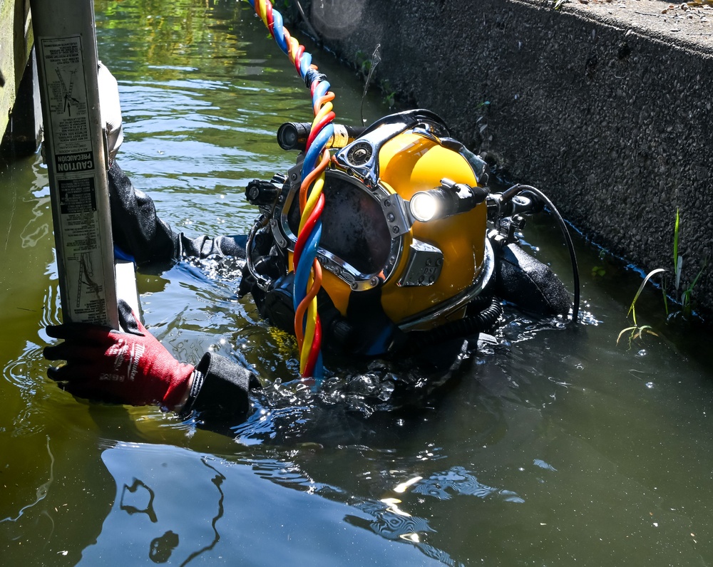 Illustrative photograph of a helmeted diver at the waterline during a seawall inspection